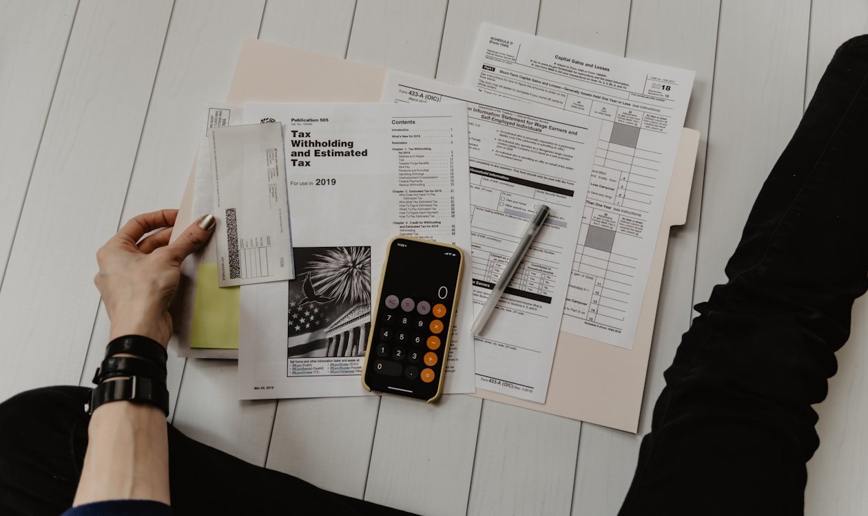 Person creating a detailed zero-based budget in a notebook with calculator and pen on desk — zero-based budgeting guide 2026